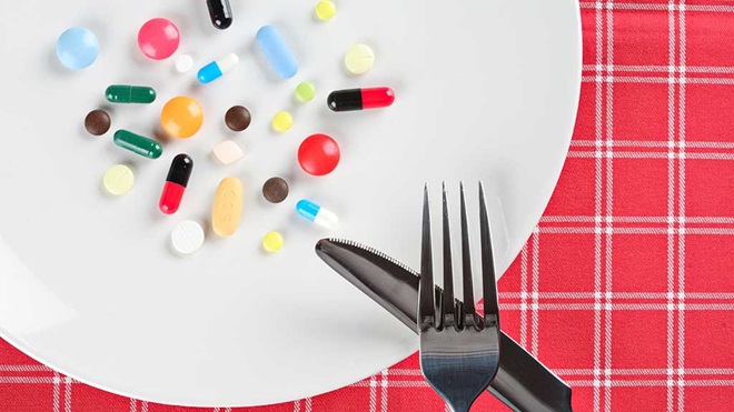 pills on a plate with knife and fork